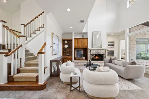 a living room with fireplace furniture and a large window