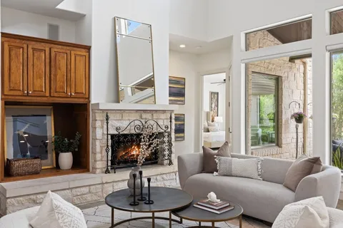 a living room with furniture a fireplace and a large window