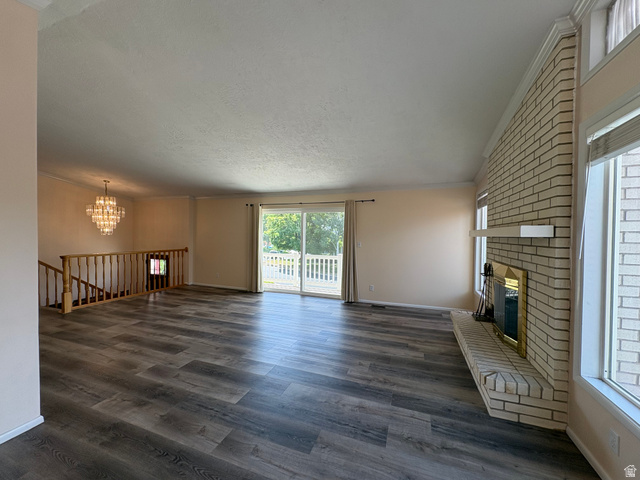 595 Meadowlark Road Orem, UT 84097 - Photo 12 of 87 Spacious living area featuring wood-finish flooring, a light brick fireplace with a hearth and mantel, and large windows