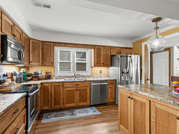 a kitchen with stainless steel appliances granite countertop a sink stove and refrigerator