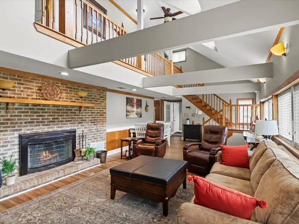 a living room with furniture a fireplace and a large window