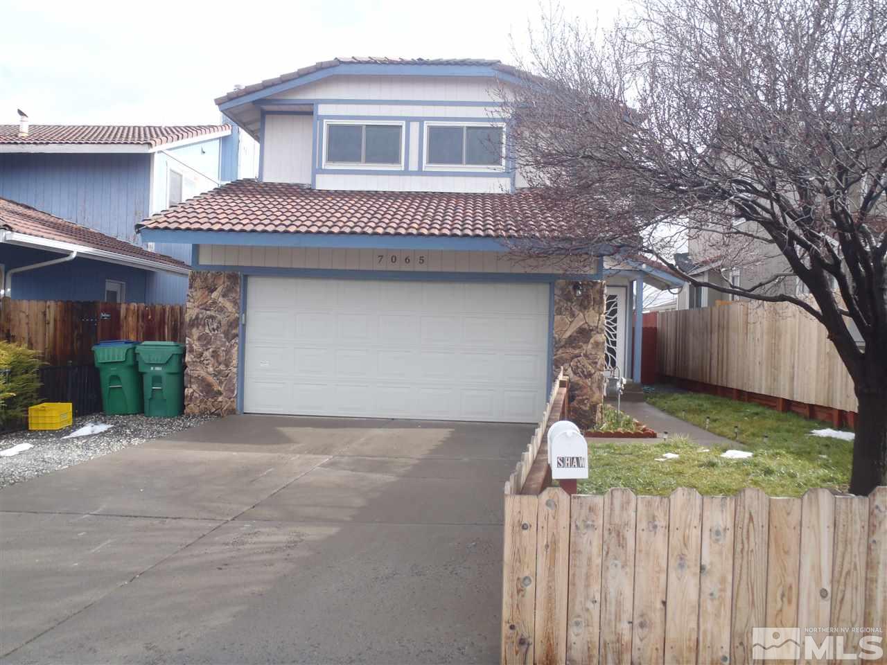 7065 Peppermint Drive Reno, NV 89506 - Photo 1 of 1 a front view of house with yard and trees in the background