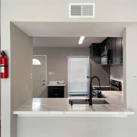 a kitchen with kitchen island a sink stainless steel appliances and cabinets
