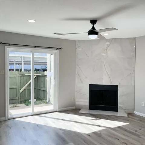 a view of empty room with wooden floor and fireplace