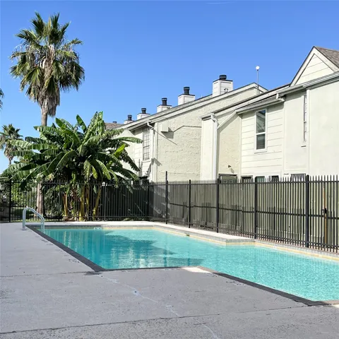 a view of a white house with a small yard and plants