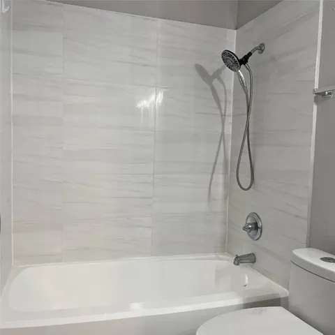 a bathroom with a bath tub with a shower