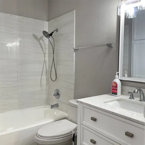 a bathroom with a granite countertop sink a toilet and shower