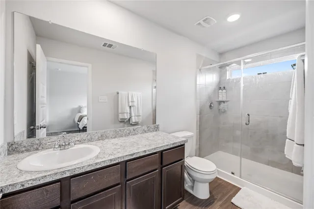 a bathroom with a granite countertop sink toilet and shower