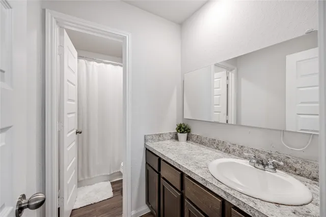 a bathroom with a granite countertop sink and a mirror