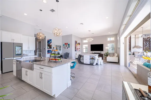 a view of kitchen with stainless steel appliances kitchen island granite countertop dining room cabinets and a view of living room