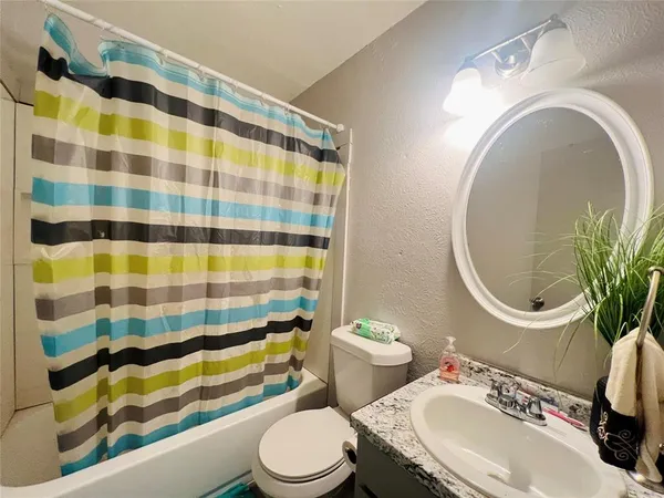 a bathroom with a sink toilet mirror and shower
