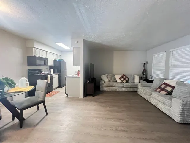 a living room with furniture and kitchen view