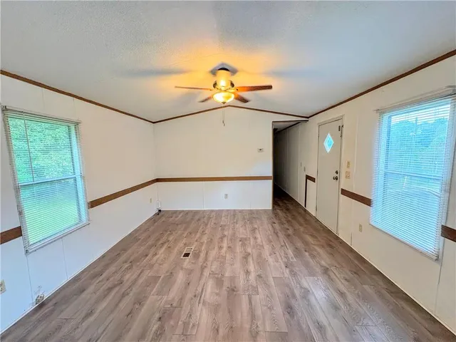 a view of empty room with wooden floor