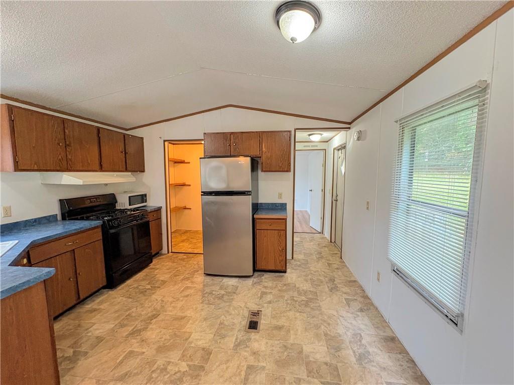 1560 Grindle Bridge Road Dahlonega, GA 30533 - Photo 6 of 21 a kitchen with a refrigerator sink and wooden cabinets