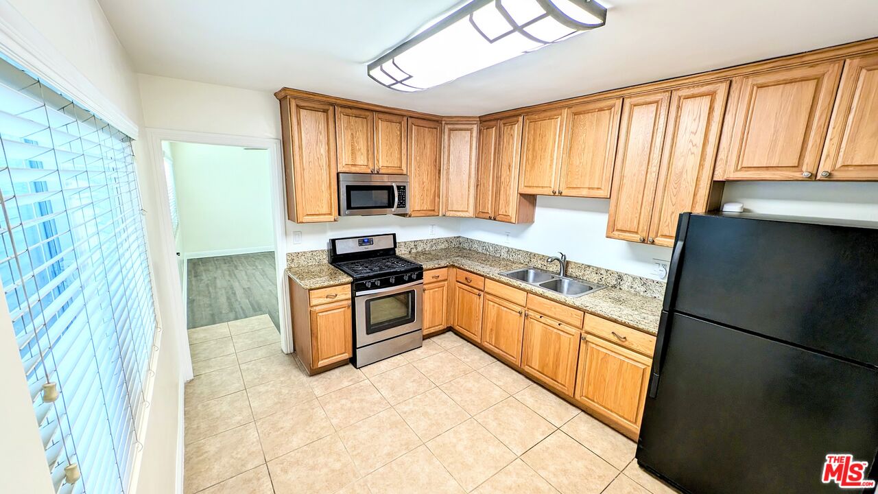 11246 Culver Boulevard Culver City, CA 90230 - Photo 5 of 13 a kitchen with stainless steel appliances granite countertop a refrigerator a stove top oven a sink and cabinets
