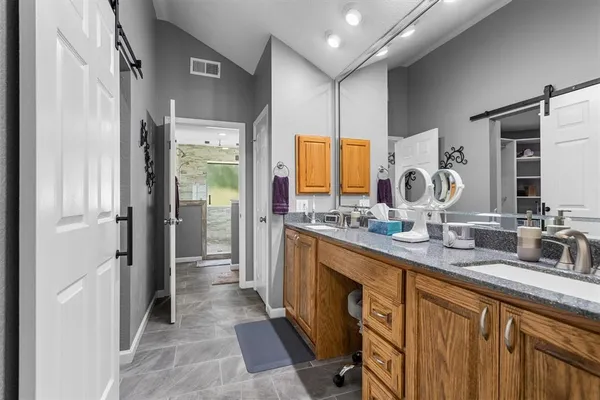 a bathroom with a double vanity sink a mirror and a shower