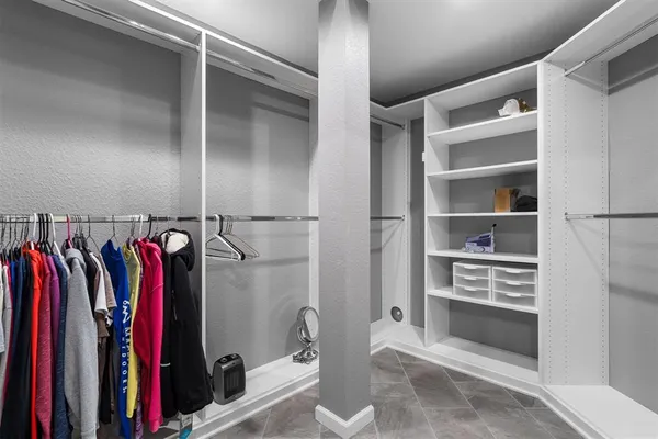 a view of walk in closet with clothes and shoes
