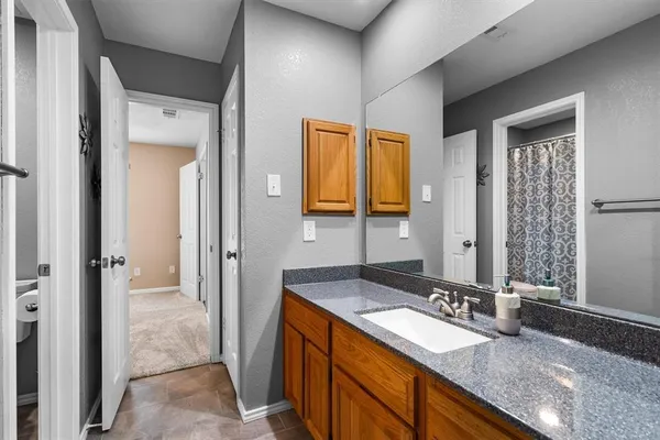 a bathroom with a granite countertop sink and a mirror