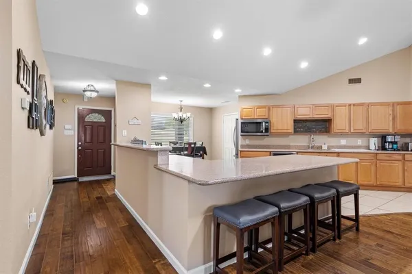a kitchen with stainless steel appliances granite countertop a refrigerator and a stove top oven
