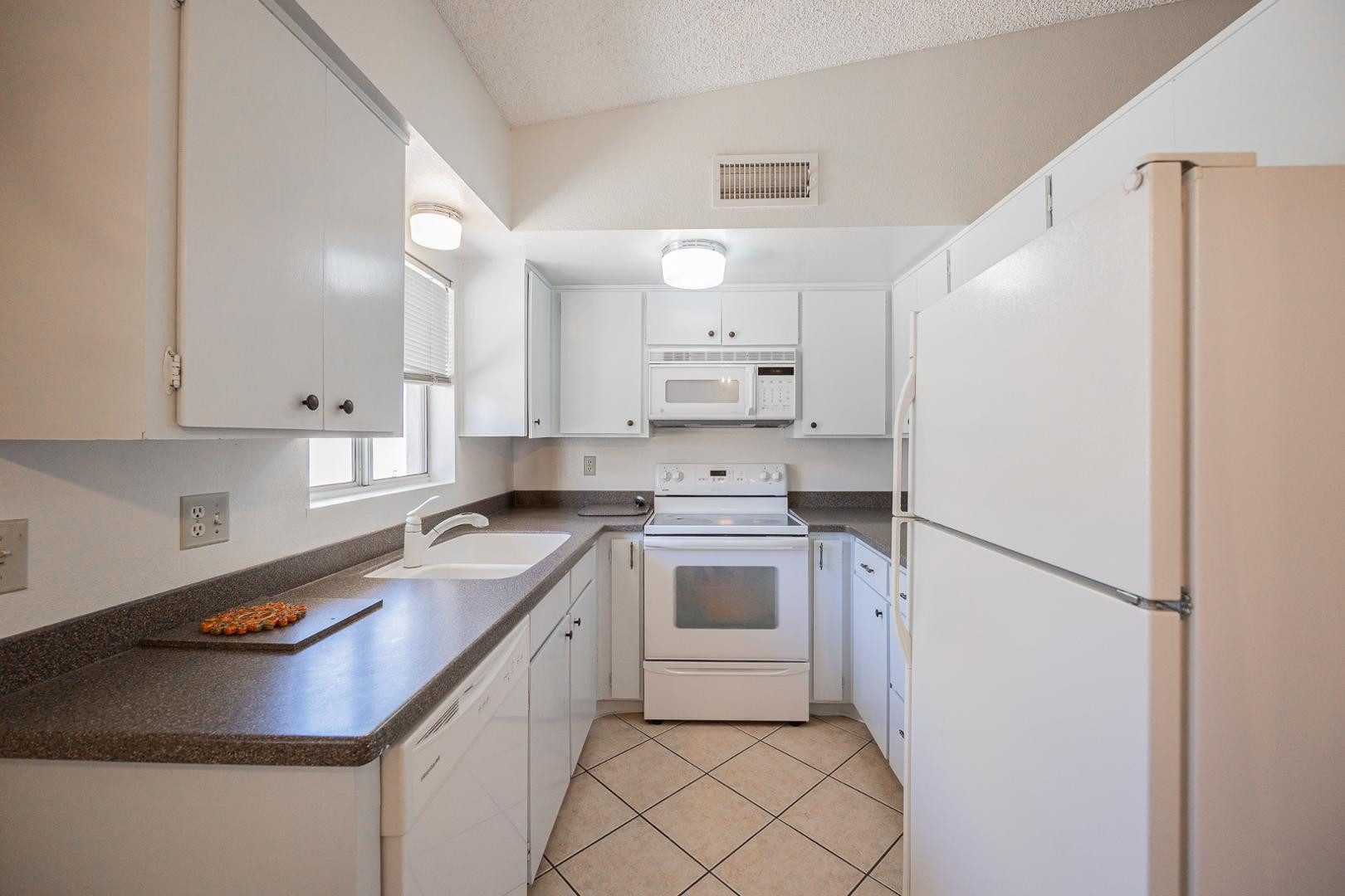 609 South Power Road, Unit 338 Mesa, AZ 85206 - Photo 10 of 24 a kitchen with a sink a stove a refrigerator and white cabinets