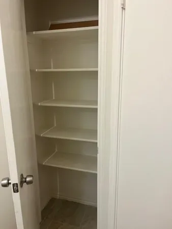 a view of walk in closet with empty racks