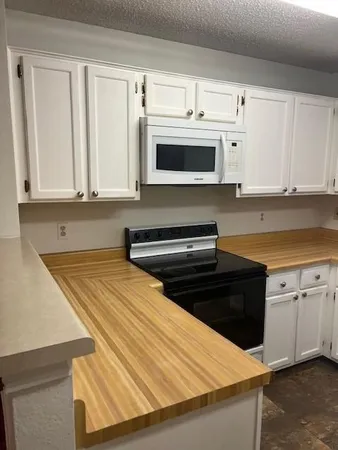 a kitchen with stainless steel appliances a stove microwave and cabinets