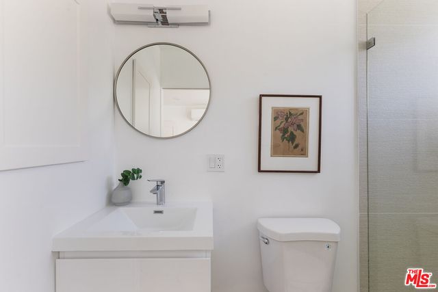 a bathroom with a toilet a sink and mirror