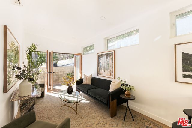 a living room with furniture and a floor to ceiling window