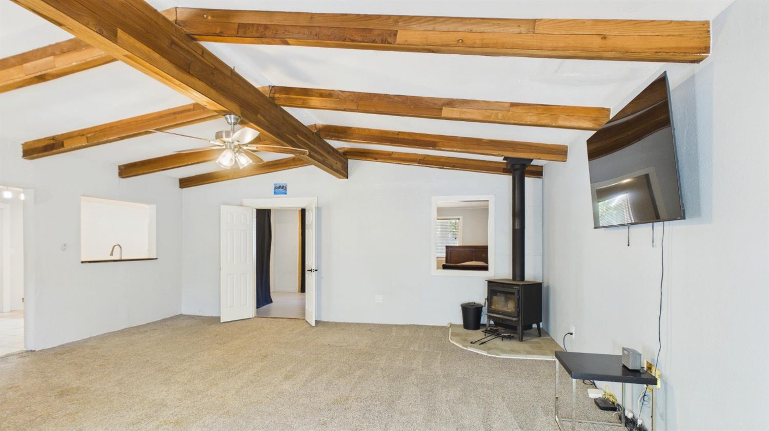 735 Ridge Road Mokelumne Hill, CA 95245 - Photo 11 of 24 Living/Dining Room featuring vaulted ceilings exposed wooden beams and a wood-burning stove with hearth