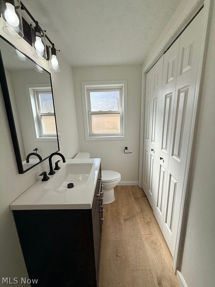 144 Aberdeen Road Steubenville, OH 43953 - Photo 18 of 34 Bathroom with vanity, light wood finished floors, a textured ceiling, and a closet