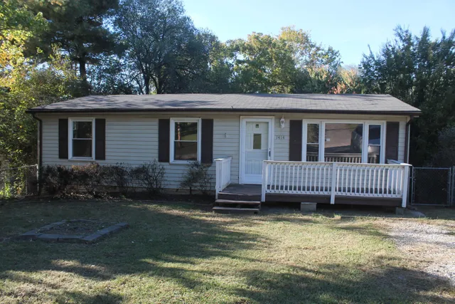 a view of a house with a yard and deck
