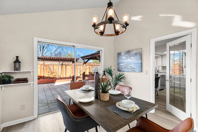a view of a dining room with furniture a chandelier and wooden floor