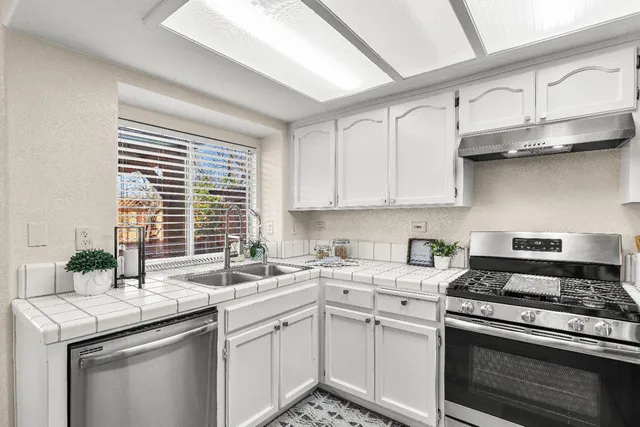 a kitchen with stainless steel appliances granite countertop a sink stove and cabinets