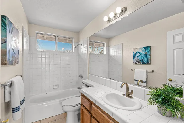 a bathroom with a sink a toilet a mirror and shower