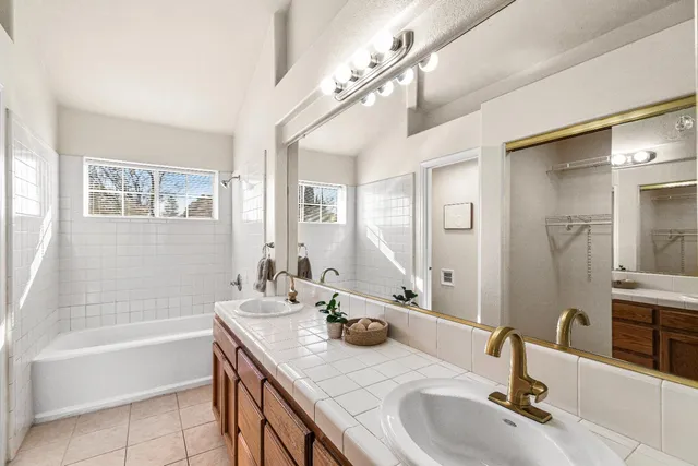 a bathroom with a tub sink and mirror