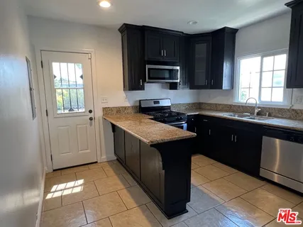 a bathroom with a granite countertop sink toilet a mirror and shower
