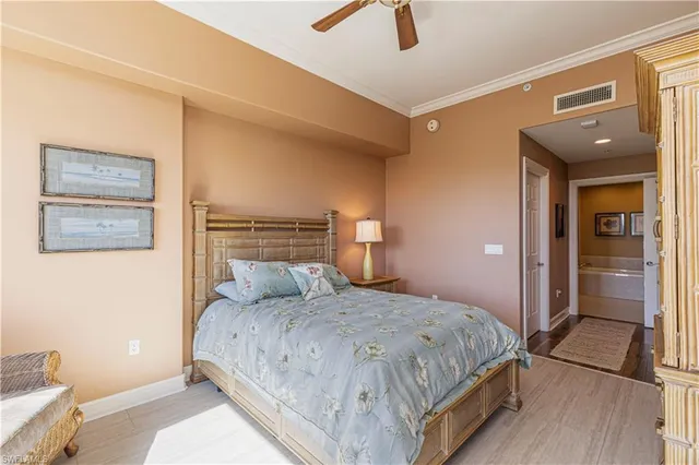 a bedroom with a bed and painting on the wall