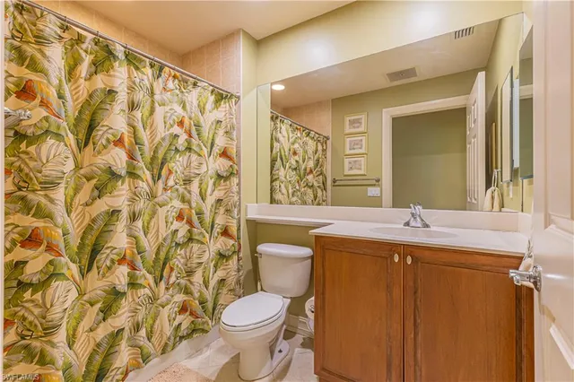 a bathroom with a granite countertop sink a toilet and a mirror