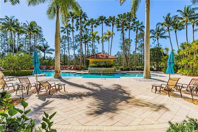 a view of a swimming pool with sitting area and furniture