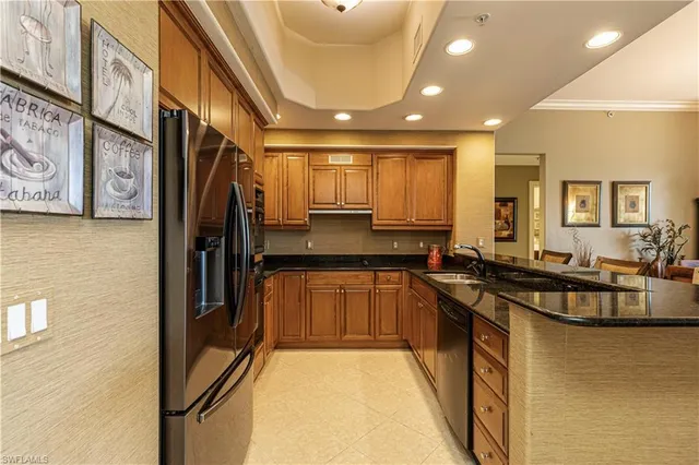 a kitchen with stainless steel appliances granite countertop a sink a stove and a refrigerator