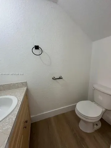 a bathroom with a granite countertop toilet and a sink
