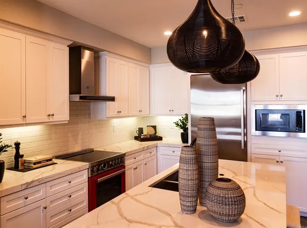 a kitchen with stainless steel appliances kitchen island granite countertop a sink a stove and cabinets