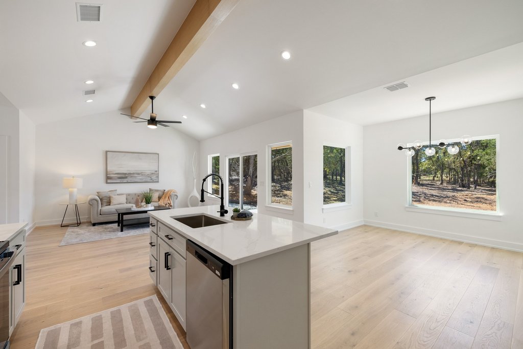 408 Rust Ranch Road Blanco, TX 78606 - Photo 34 of 34 Kitchen with open floor plan, light wood finished floors, stainless steel dishwasher, light stone countertops, and beam ceiling