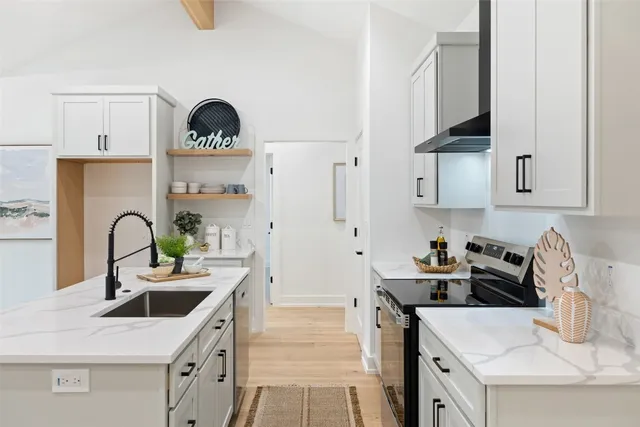 a kitchen with kitchen island a sink a stove and cabinets