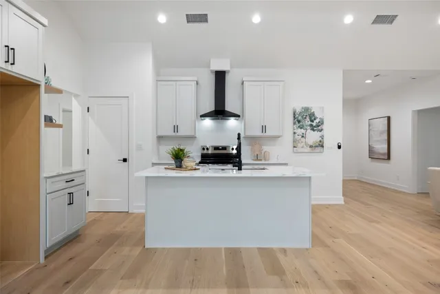 a kitchen with stainless steel appliances a stove refrigerator and cabinets