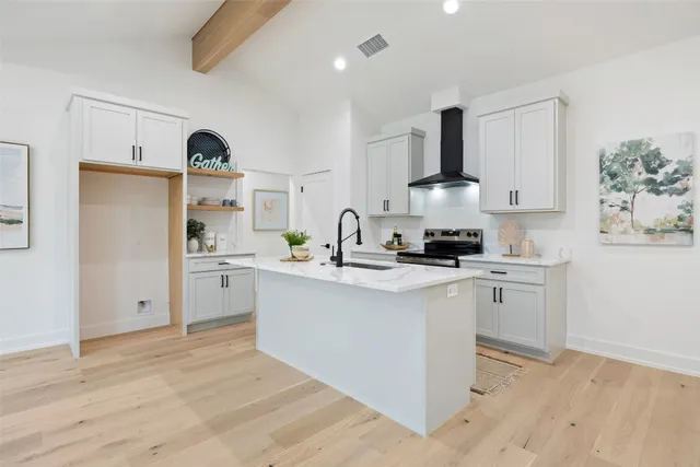 a kitchen with stainless steel appliances a sink a stove a refrigerator and cabinets