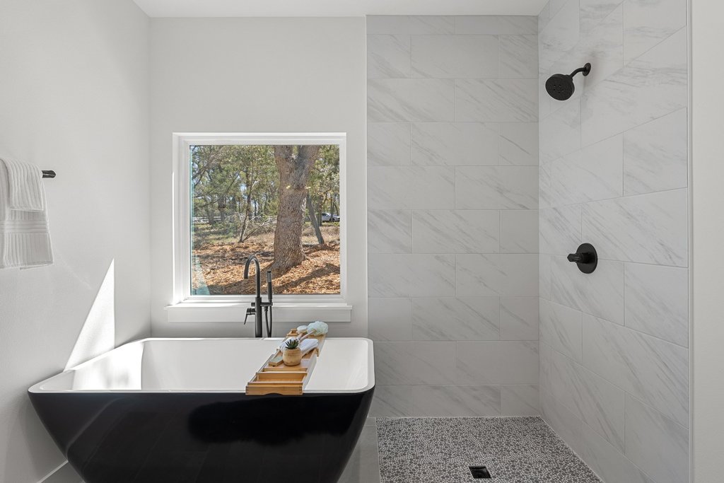 408 Rust Ranch Road Blanco, TX 78606 - Photo 16 of 34 Full bathroom featuring a freestanding tub and a tile shower