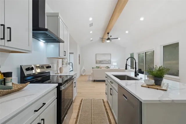 a kitchen with stainless steel appliances a sink stove and cabinets