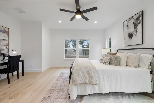 a bedroom with a large bed and a chandelier
