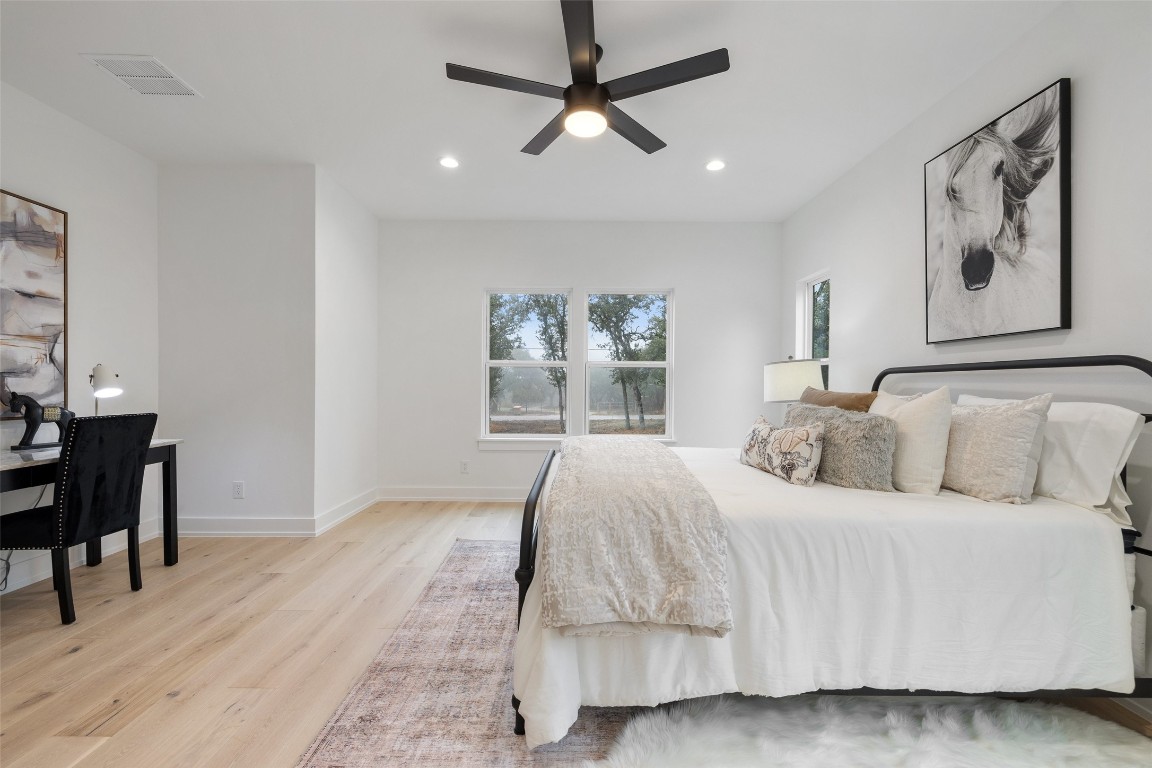 408 Rust Ranch Road Blanco, TX 78606 - Photo 21 of 35 a bedroom with a large bed and a chandelier